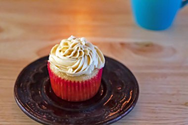 Buzlu kek, ahşap bir masa ve arka planda biraz sigara.