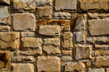 Eski, sarı taştan bir duvarın arka plan dokusu.