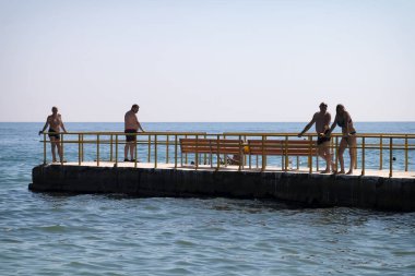 ODESSA, UKRAINE - Yaşlı insanlar Odessa sahilinin iskelesinde dinleniyor.