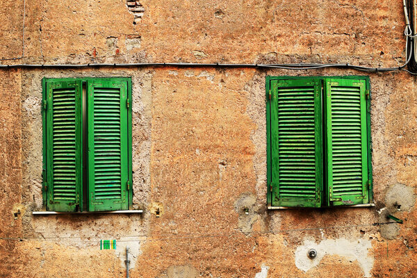 Window closed old green wooden shutters, Italy