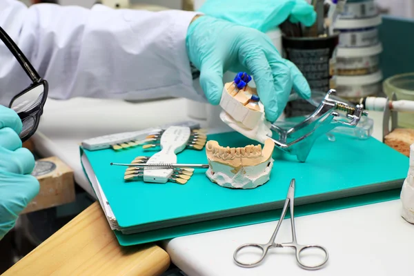 Técnico dental comprueba su trabajo — Foto de Stock