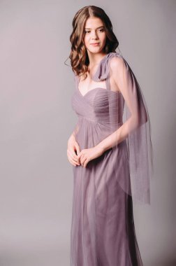 Şık bir elbise. Güzel leylak şifon gece elbisesi. Genç esmer kadının stüdyo portresi. Nedime elbiseleri.