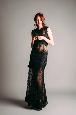 Siyah şeffaf uzun gece elbisesi. Güzel ince bükme modeli, modern kadınsı bir parti arayışı. Kadın modası.