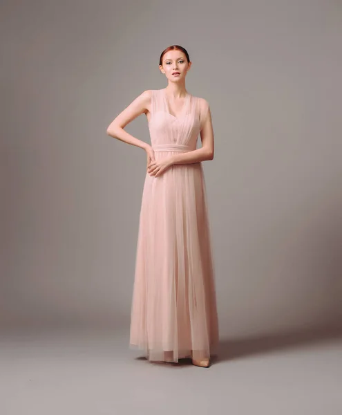 Bridesmaid\'s dresses. Elegant moscato dress. Beautiful pink chiffon evening gown. Studio portrait of young brunette woman. Transformer dress idea for celebration.