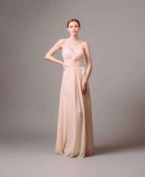 Bridesmaid\'s dresses. Elegant moscato dress. Beautiful pink chiffon evening gown. Studio portrait of young happy ginger woman. Transformer dress idea for an event.