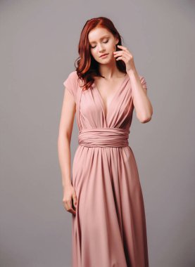 Zarif somon transformatörü elbisesi. Koyu yakalı ve omuz bantlı, güzel, seksi ipek gece elbisesi. Kızıl saçlı genç bir kadının stüdyo portresi. Nedimenin şık görünüşü..