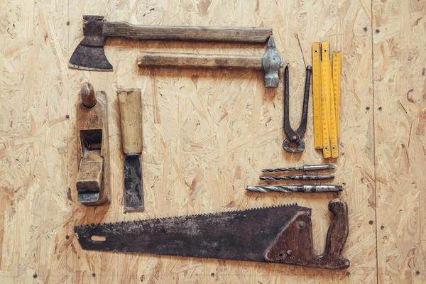 Old construction tools on a wooden workbench flat lay background. Carpenter table. Woodwork — Stock Photo, Image