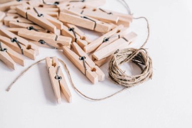 Beyaz arka planda ipli ahşap mandallar. Yukarıdan bak. Boşluğu kopyala.