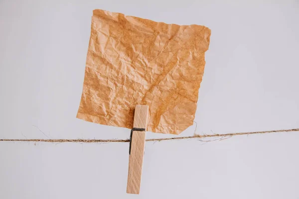 Brown stickers on clothesline with wooden clothespin isolated on white background. Place for your text.