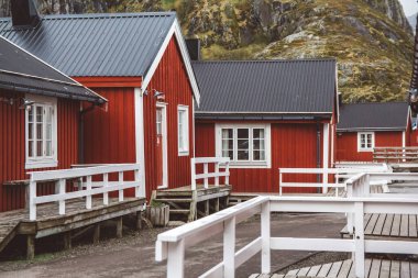 Norveç evleri ve dağları fiyort üzerindeki kayalar İskandinav seyahat manzarası Lofoten adaları.