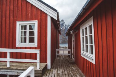 Norveç evleri ve dağları fiyort üzerindeki kayalar İskandinav seyahat manzarası Lofoten adaları.