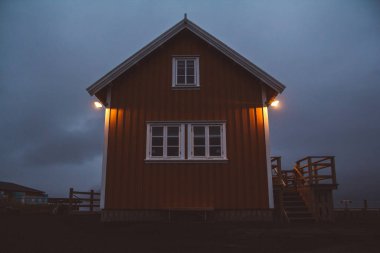 Norveç evleri ve dağları fiyort üzerindeki kayalar İskandinav seyahat manzarası Lofoten adaları.
