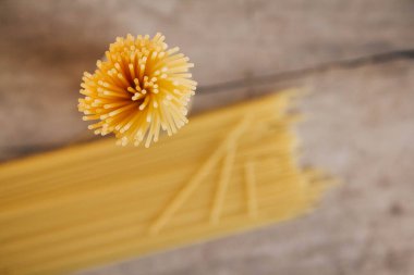 Eski ahşap arka planda sarı, uzun bir spagetti. Yemek konsepti geçmişi. Üst Manzara. Kopyala, metin için boşluk.