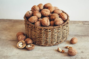 Tahta bir arka planda, sepetin içinde cevizler..