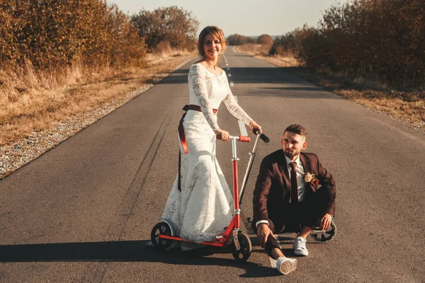 日落时分 在城外的路上骑着摩托车 笑逐颜开的新婚夫妇 — 图库照片