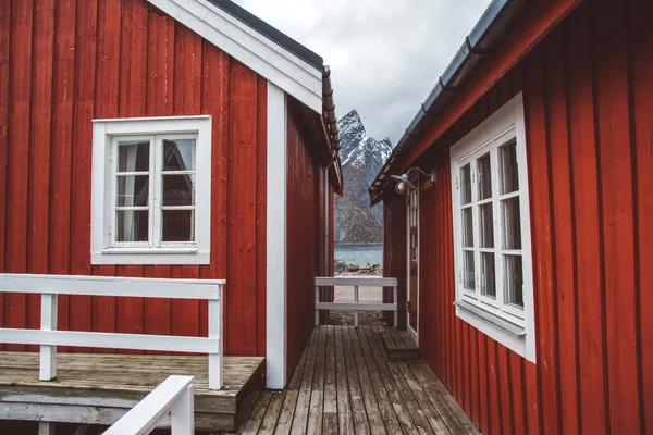 Norveç evleri ve dağları fiyort üzerindeki kayalar İskandinav seyahat manzarası Lofoten adaları.