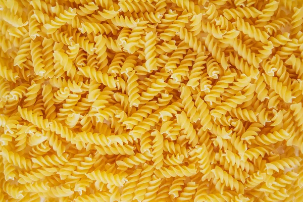 Arka plan görüntüsü olarak Fusilli makarna. Görüntü dokusu sarmal makarna. Üst Manzara. Kopyala, metin için boşluk.