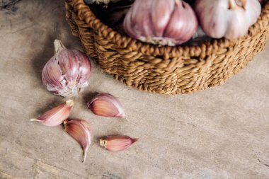 Tahta bir arka planda hasır sepette sarımsak. Üst Manzara. Kopyala, metin için boşluk.