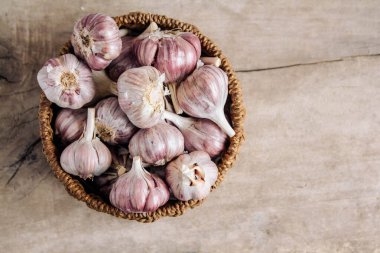 Tahta bir arka planda hasır sepette sarımsak. Üst Manzara. Kopyala, metin için boşluk.