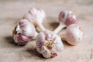 Sarımsaklar ahşap bir arka planda yatar. Kopyala, metin için boşluk.