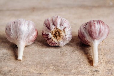 Kırsal ahşap arka planda sarımsak ampulü. Kopyala, metin için boşluk.