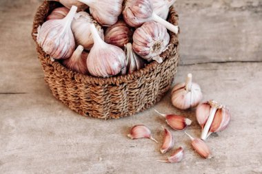 Tahta bir arka planda hasır sepette sarımsak. Üst Manzara. Kopyala, metin için boşluk.