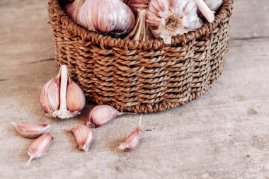 Tahta bir arka planda hasır sepette sarımsak. Üst Manzara. Kopyala, metin için boşluk.