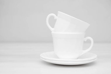 Beyaz tabakları olan beyaz seramik bardaklar. Metin için boşluk.