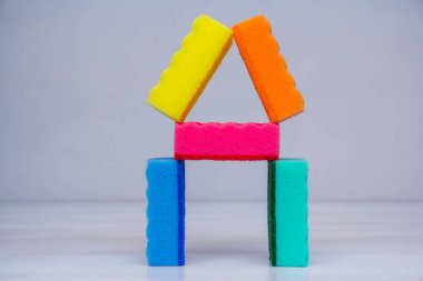 Beyaz bir masada bulaşık yıkamak ve temizlemek için çok renkli süngerler. Metin için boşluk.