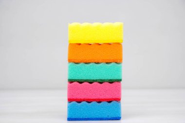 Beyaz bir masada bulaşık yıkamak ve temizlemek için çok renkli süngerler. Metin için boşluk.