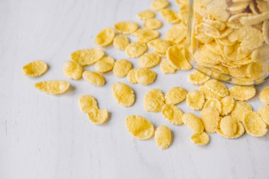 Beyaz ahşap yüzeyde cam bir kavanozda mısır gevreği. Üst Manzara. Metnin için yer.