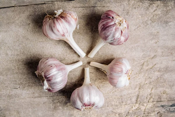 Sarımsaklar ahşap bir arka planda yatar. Üst Manzara. Kopyala, metin için boşluk.