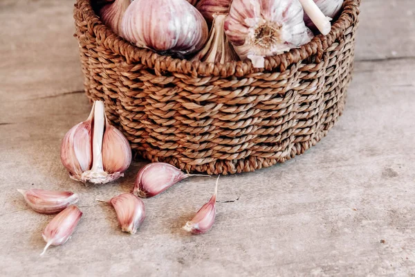 Tahta bir arka planda hasır sepette sarımsak. Üst Manzara. Kopyala, metin için boşluk.
