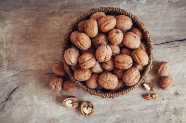 Tahta bir arka planda, sepetin içinde cevizler. Üst Manzara. Kopyala, metin için boşluk.