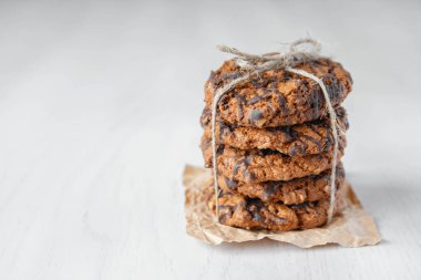 Beyaz masa arkasında çikolata parçacıklı kurabiyeler. Kopyala, metin için boşluk.