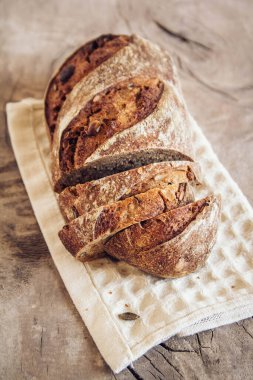Tohumlu kahverengi taze ekmek eski ahşap arka planda parçalara ayrılır. Üst görünüm, alanı kopyala.
