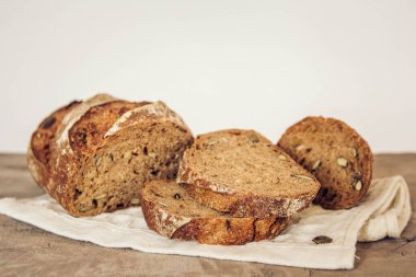 Tohumlu kahverengi taze ekmek eski ahşap arka planda parçalara ayrılır. Üst görünüm, alanı kopyala.
