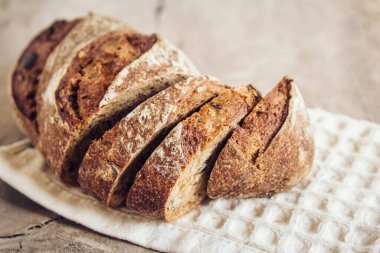 Tohumlu kahverengi taze ekmek eski ahşap arka planda parçalara ayrılır. Üst görünüm, alanı kopyala.