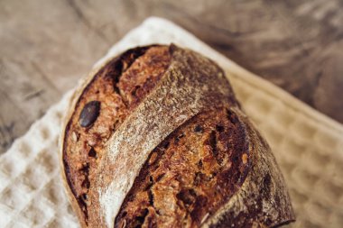 Tohumlu kahverengi taze ekmek eski ahşap arka planda parçalara ayrılır. Üst görünüm, alanı kopyala.