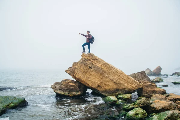 Man stand on cliff edge alone enjoying aerial view backpacking lifestyle travel adventure outdoor vacations.