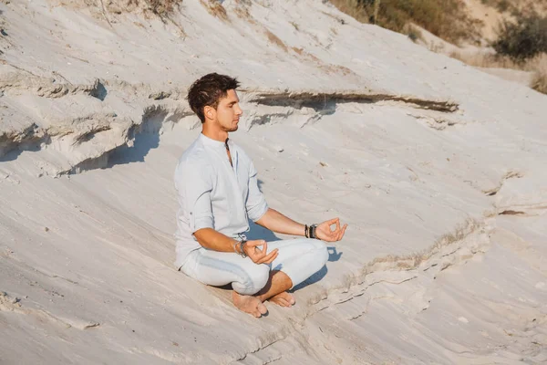 Mladý Pohledný Muž Oblečený Lehkém Oblečení Sedí Meditaci Písečné Pláži — Stock fotografie
