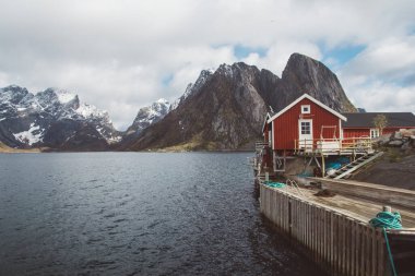 Norveç evleri ve dağları fiyort üzerindeki kayalar İskandinav seyahat manzarası Lofoten adaları.