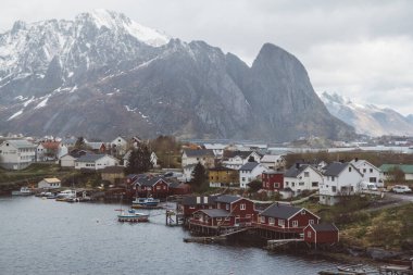 Norveç evleri ve dağları fiyort üzerindeki kayalar İskandinav seyahat manzarası Lofoten adaları.