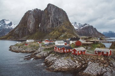 Norveç evleri ve dağları fiyort üzerindeki kayalar İskandinav seyahat manzarası Lofoten adaları.