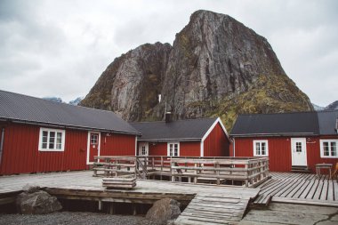Norveç evleri ve dağları fiyort üzerindeki kayalar İskandinav seyahat manzarası Lofoten adaları.