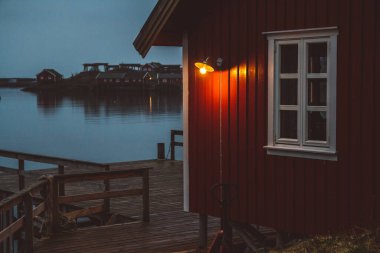 Norveç evleri ve dağları fiyort üzerindeki kayalar İskandinav seyahat manzarası Lofoten adaları.