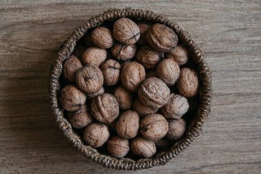 Tahta bir arka planda, sepetin içinde cevizler. Üst Manzara. Kopyala, metin için boşluk.