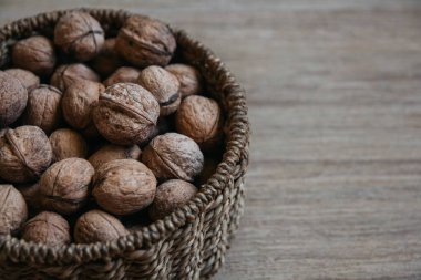 Tahta bir arka planda, sepetin içinde cevizler. Üst Manzara. Kopyala, metin için boşluk.