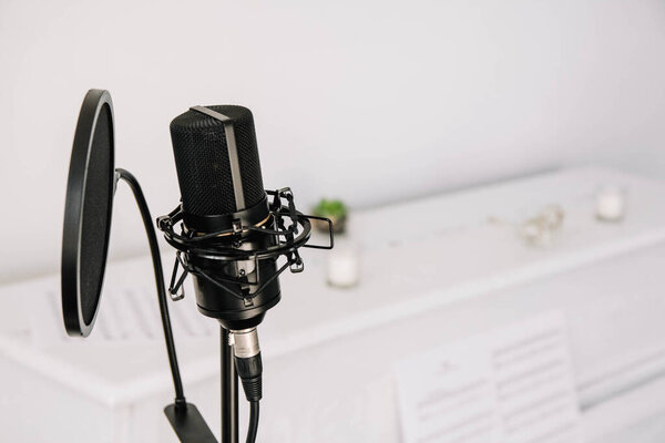 Professional studio microphone on a modern tripod, very convenient and practical. White background.