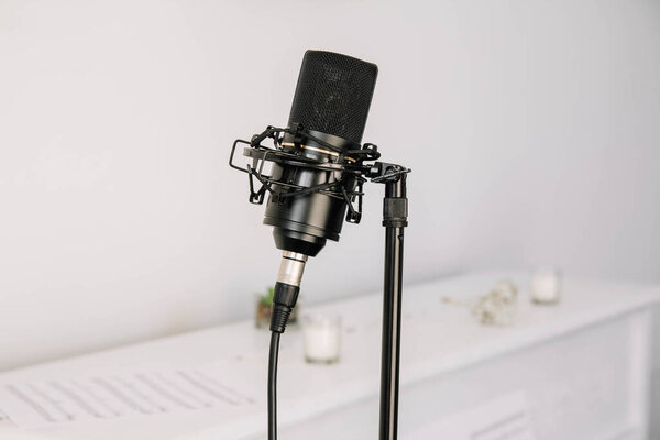 Professional studio microphone on a modern tripod, very convenient and practical. White background.